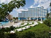 Pohled na hotel zvenku s bazénem a lehátky